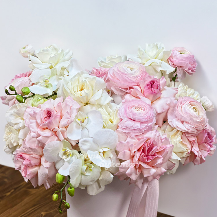 Коробка роз, ранункулюсов и орхидей (крупный план)