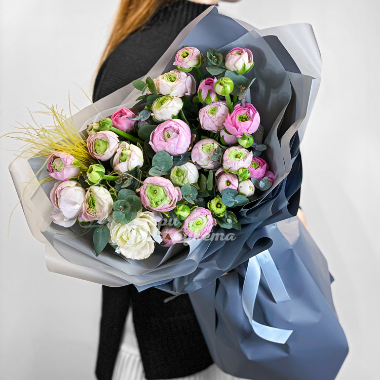 Букет розовых ранункулюсов с зеленью (в руках флориста)